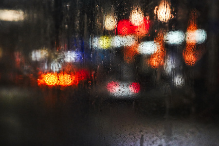 Through the misted glass in the bus video the night city with bright lights and cars