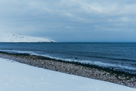 Rocky coast of the Arctic Ocean in the snow in winter while travelingの写真素材