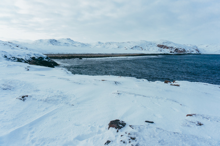 The shore of the northern ocean is covered with ice on a winter frosty day during the expeditionの写真素材