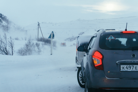 Teriberka, Murmansk region / Russia - February 2018: The car moves along the snow-covered road to snowfall in winter in difficult weather conditionsのeditorial素材
