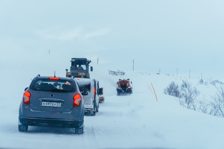 Teriberka, Murmansk region / Russia - February 2018: The column of cars is moving along a snow-covered highway for road machinery into a strong blizzardのeditorial素材