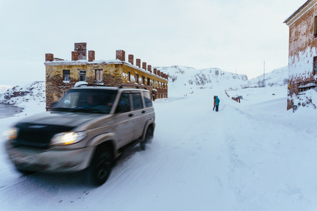 Teriberka, Murmansk region / Russia - February 2018: The car moves along the snow-covered road to snowfall in winter in difficult weather conditionsのeditorial素材