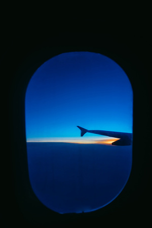 During the journey, look through the porthole of the new aircraft to the blue sky and white shelvesの写真素材