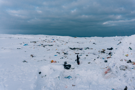 Garbage dump on clean white snow outside the city on the road people spoil the nature of the village...