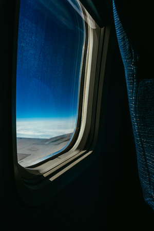 During the journey, look through the porthole of the new aircraft to the blue sky and white shelvesの写真素材