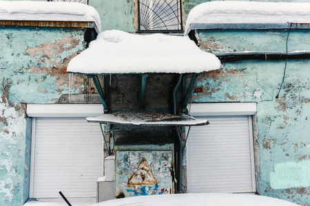 A typical tall old green house in poor condition with a shabby old paint and inscriptionsの写真素材