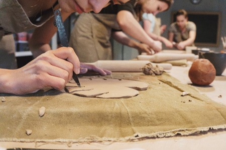 Making dirty hands of raw clay ware in a pottery workshopの写真素材