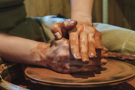 Making dirty hands of raw clay ware in a pottery workshopの写真素材