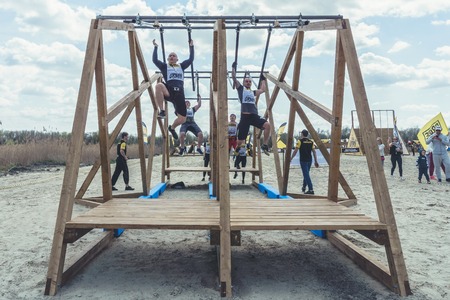 Rostov-on-Don / Russia - April 2018: Organized team run with obstacles in rough terrain with wooden structures on sandのeditorial素材
