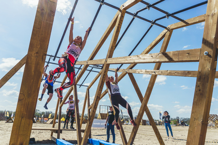 Rostov-on-Don / Russia - April 2018: Organized team run with obstacles in rough terrain with wooden...