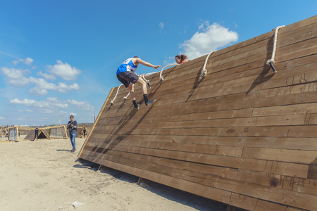 Rostov-on-Don / Russia - April 2018: Organized team run with obstacles in rough terrain with wooden...