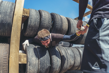 Rostov-on-Don / Russia - April 2018: Organized team run with obstacles in rough terrain with wooden structures on sandのeditorial素材