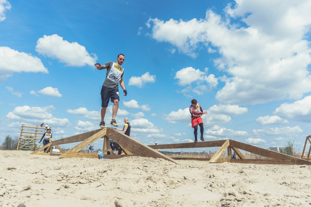 Rostov-on-Don / Russia - April 2018: Organized team run with obstacles in rough terrain with wooden...