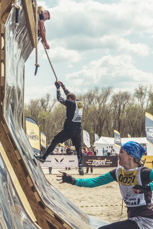 Rostov-on-Don / Russia - April 2018: Organized team run with obstacles in rough terrain with wooden...