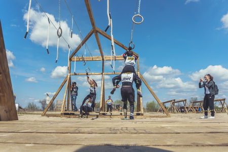 Rostov-on-Don / Russia - April 2018: Organized team run with obstacles in rough terrain with wooden...