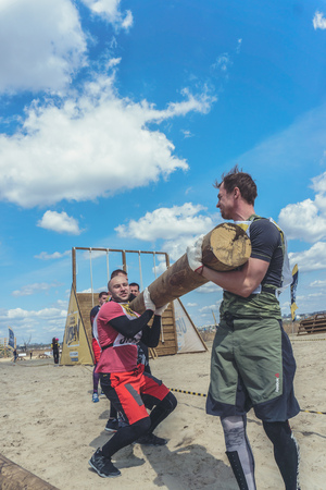Rostov-on-Don / Russia - April 2018: Organized team run with obstacles in rough terrain with wooden structures on sandのeditorial素材