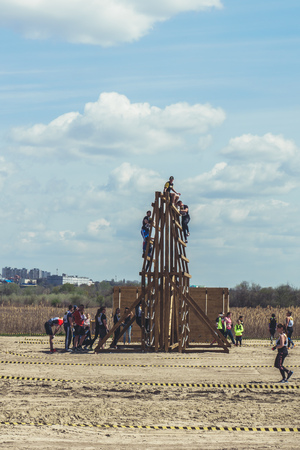 Rostov-on-Don / Russia - April 2018: Organized team run with obstacles in rough terrain with wooden structures on sandのeditorial素材