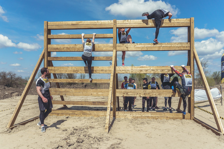 Rostov-on-Don / Russia - April 2018: Organized team run with obstacles in rough terrain with wooden...