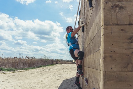 Rostov-on-Don / Russia - April 2018: Organized team run with obstacles in rough terrain with wooden...