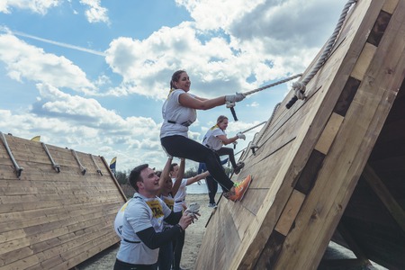 Rostov-on-Don / Russia - April 2018: Organized team run with obstacles in rough terrain with wooden...