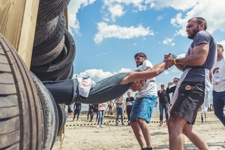 Rostov-on-Don / Russia - April 2018: Organized team run with obstacles in rough terrain with wooden...