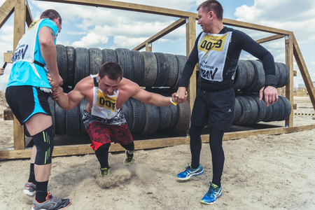 Rostov-on-Don / Russia - April 2018: Organized team run with obstacles in rough terrain with wooden structures on sandのeditorial素材