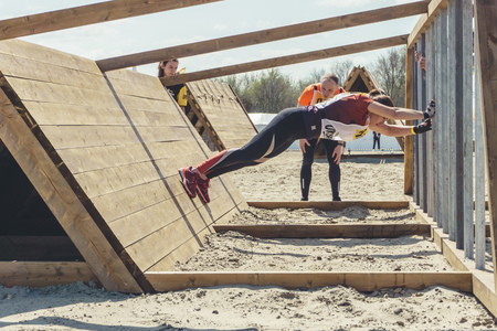Rostov-on-Don / Russia - April 2018: Organized team run with obstacles in rough terrain with wooden structures on sandのeditorial素材
