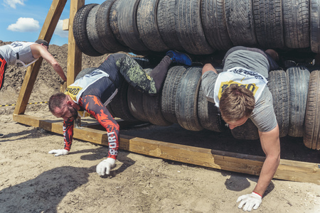Rostov-on-Don / Russia - April 2018: Organized team run with obstacles in rough terrain with wooden structures on sandのeditorial素材