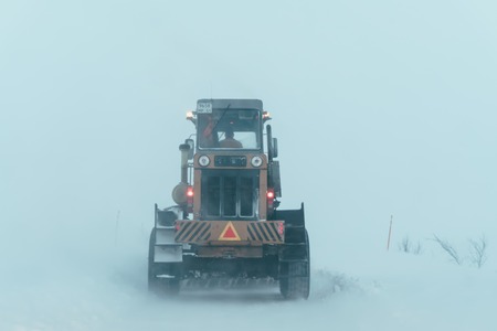 Teriberka, Murmansk region / Russia - February 2018: An automobile column moves along a snow-covered road during a blizzard and heavy snowfall behind a truck with a plowのeditorial素材