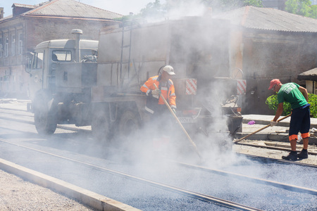 Rostov-on-Don / Russia - May 2018: Laying of asphalt on the road and pouring a liquid mixture between rails on new tram tracks during the reconstruction of Stanislavsky Streetのeditorial素材