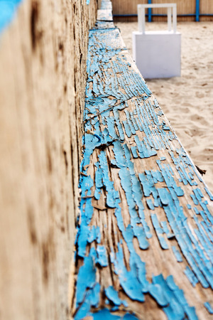 On the wooden surface, the last traces of the old paint of blue are peeling off and the texture of the bare wood appearsの写真素材