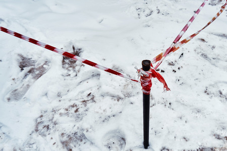 Fencing tape warns of the danger of icicles in winter in winter along the houseの写真素材