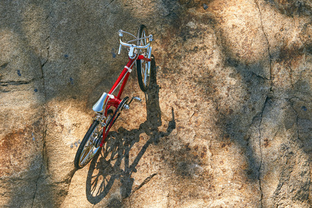 red metal toy bike on the lake with clear water on a clear sunny day in summer while travelingの写真素材