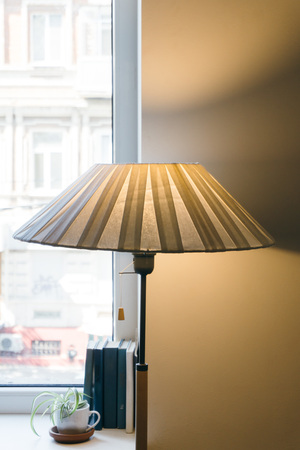 table retro lamp is on the old table in a classic interior and illuminates with its beautiful light a large roomの写真素材