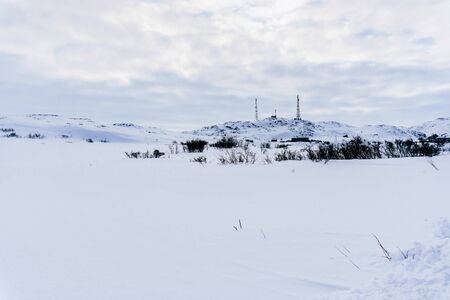 high metal towers for cellular and internet on a hill surrounded by snow in the tundra on a frosty winter day high metal towers for cellular and internet on a hill surrounded by snow in the tundra on a frosty winter day