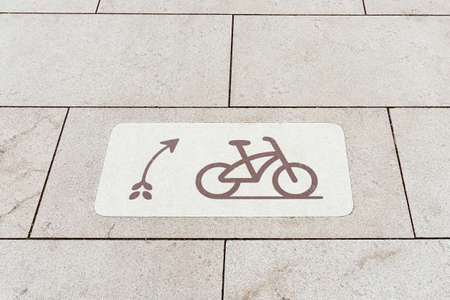 unusual tile showing the movement of a bicycle on a bicycle path laid on a new sidewalk fits in with the design and style of the new parkの写真素材