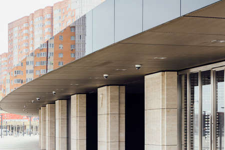 curved semicircular entrance to a new modern stadium separated by columns and shiny panels waiting...
