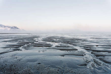 the low tide in the North sea in winter on a frosty day exposed the bottom with sand and ice