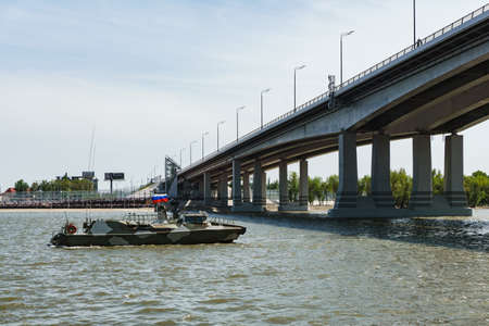 Rostov-on-Don / Russia - May 2018: a river parade of warships in honor of the holiday near the city embankment pass under the new automobile bridge over the Don on a clear warm dayのeditorial素材