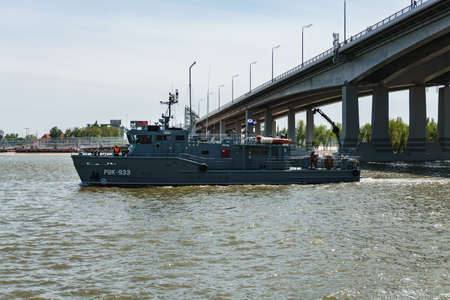 Rostov-on-Don / Russia - May 2018: a river parade of warships in honor of the holiday near the city embankment pass under the new automobile bridge over the Don on a clear warm dayのeditorial素材