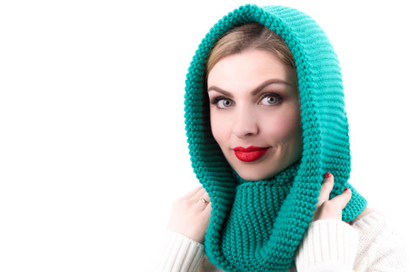 A beautiful young woman dressed in a bright knitted scarfの写真素材