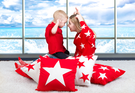 Young mother and little son playing. The concept of a family holiday. Beautiful pillows to decorate the interior of the house.family vacation conceptの写真素材