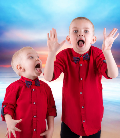 Two brothers playing and having fun, Hamming spending time together.They wear the same trendy clothing, shirts.の写真素材