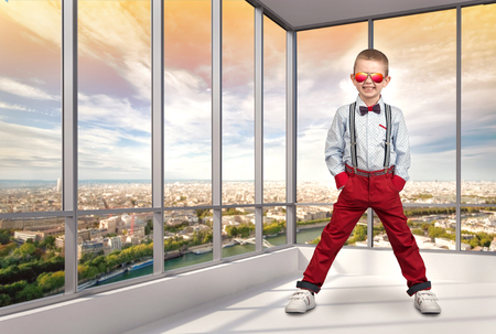 Stylish boy in fashionable clothes and sunglasses from the sun in the office. Children's fashion.の写真素材
