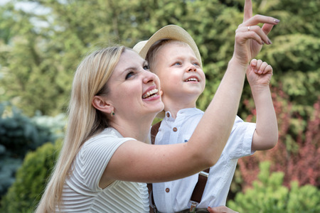 Life moment of happy family! Mother and son child playing having fun together on the grass in sunny summer dayの写真素材