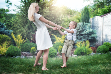 Young mother and son circling holding hands.Family vacation in the Park.の写真素材