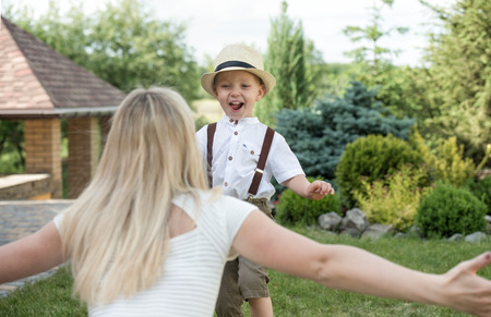 Life moment of happy family! Mother and son child playing having fun together on the grass in sunny summer dayの写真素材