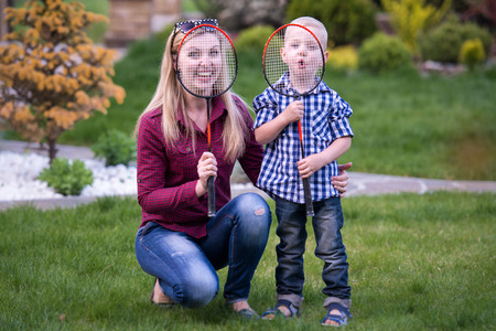Mother and little son playing badminton.の写真素材