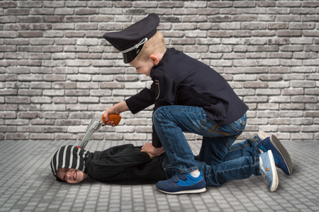 Two brothers playing COP and criminal. ?の写真素材