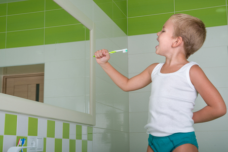 Little boy sings the song in the toothbrush in the bathroom. The future singer.の写真素材
